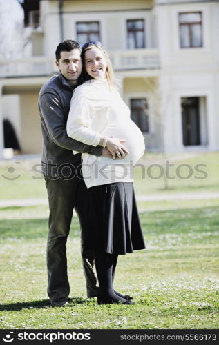 happy young married family couple outdoor in nature have fun and waiting baby and representing young family growth and pregnancy concept