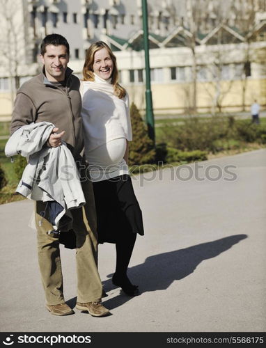 happy young married family couple outdoor in nature have fun and waiting baby and representing young family growth and pregnancy concept