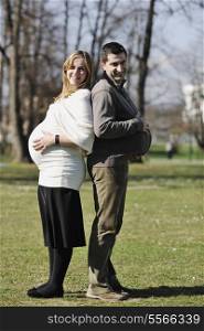 happy young married family couple outdoor in nature have fun and waiting baby and representing young family growth and pregnancy concept