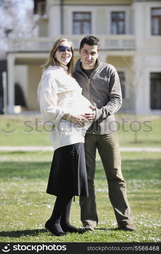 happy young married family couple outdoor in nature have fun and waiting baby and representing young family growth and pregnancy concept