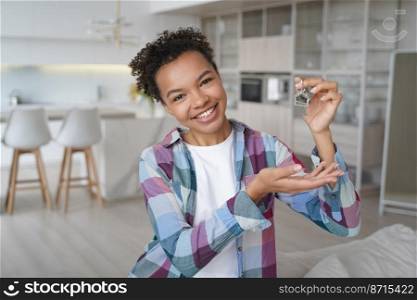 Happy young mixed race female renter showing home keys, looking at camera. Just moved girl homeowner, tenant shows key to new apartment. Real estate service, rental dwelling advertising.. Happy young mixed race girl showing home keys at camera, moved to new apartment. Real estate service