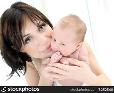 Happy young mother holding a baby