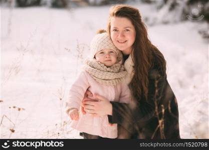 Happy young mother with daughter walk in the winter park. Close up. Portrait happy family outdoors. Happy young mother with daughter walk in the winter park. Close up. Portrait happy family outdoors.