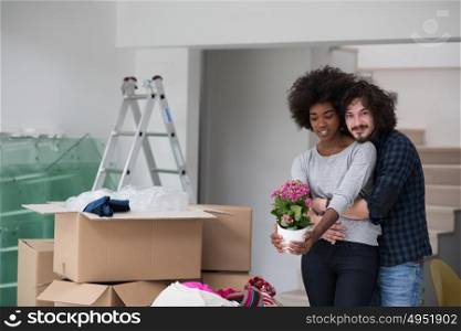 Happy young multiethnic couple unpacking or packing boxes and moving into a new home