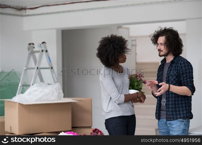 Happy young multiethnic couple unpacking or packing boxes and moving into a new home