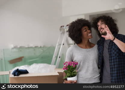 Happy young multiethnic couple unpacking or packing boxes and moving into a new home