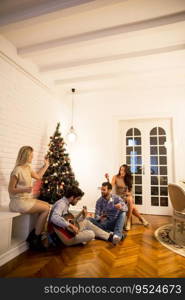 Happy Young people celebrating Christmas and New Year by fir-tree at home