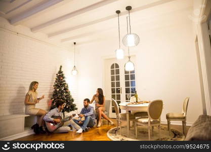 Happy Young people celebrating Christmas and New Year by fir-tree at home