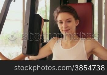 Happy young people, fun, leisure, lifestyle, fitness, sport and exercising. Beautiful caucasian young woman working out, pretty girl training with equipment in gym. Portrait looking at camera, 19of27