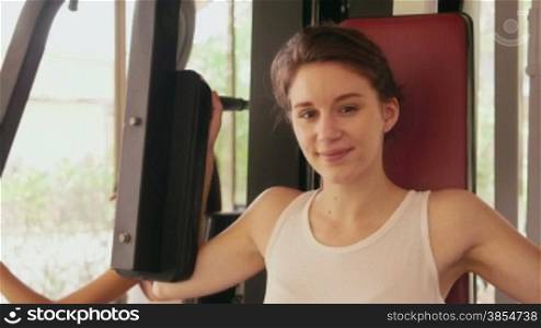 Happy young people, fun, leisure, lifestyle, fitness, sport and exercising. Beautiful caucasian young woman working out, pretty girl training with equipment in gym. Portrait looking at camera, 19of27