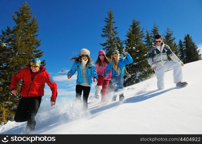 happy young people group have fun and enjoy fresh snow at beautiful winter day