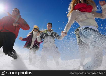 happy young people group have fun and enjoy fresh snow at beautiful winter day