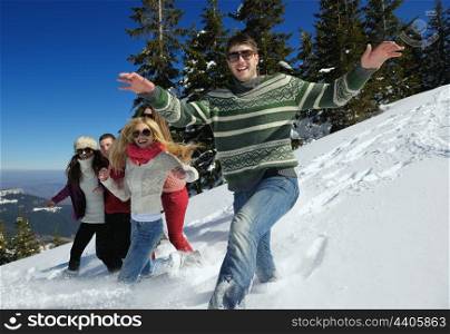 happy young people group have fun and enjoy fresh snow at beautiful winter day