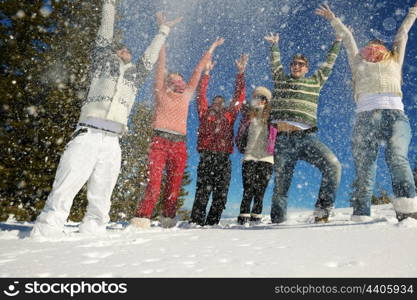 happy young people group have fun and enjoy fresh snow at beautiful winter day