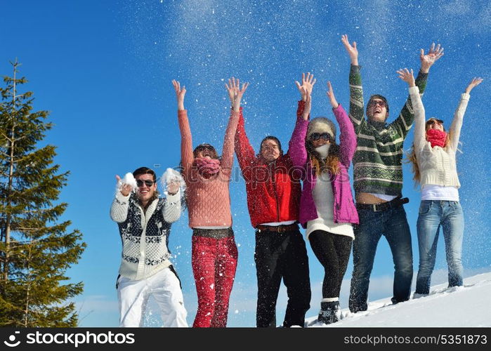 happy young people group have fun and enjoy fresh snow at beautiful winter day