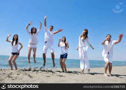 happy young people group have fun run and jump on beach beautiful sand beach