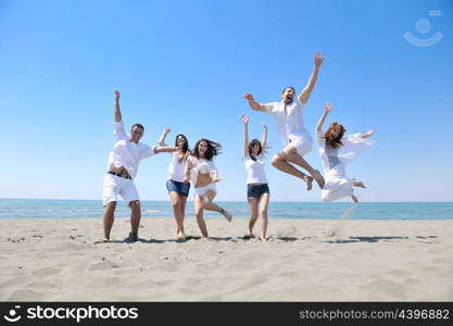 happy young people group have fun run and jump on beach beautiful sand beach