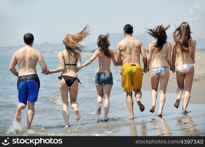 happy young people group have fun run and jump on beach beautiful sand beach