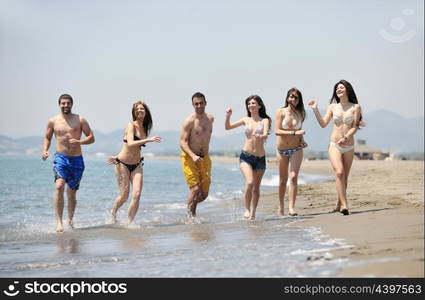 happy young people group have fun run and jump on beach beautiful sand beach