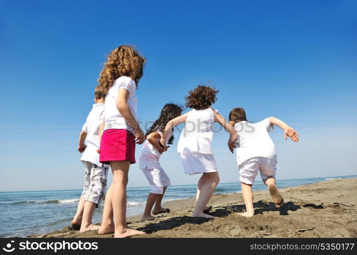 happy young people group have fun run and jump on beach beautiful sand beach