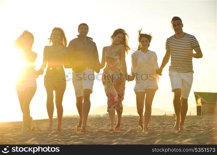 happy young people group have fun run and jump on beach beautiful sand beach