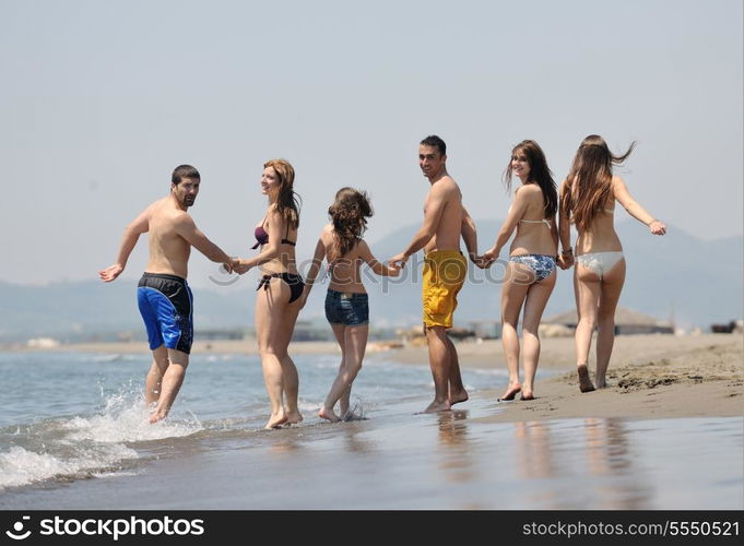 happy young people group have fun run and jump on beach beautiful sand beach