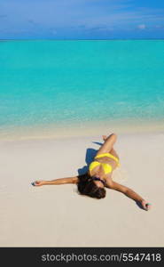 happy young pretty asian woman resting on sand at tropical beach