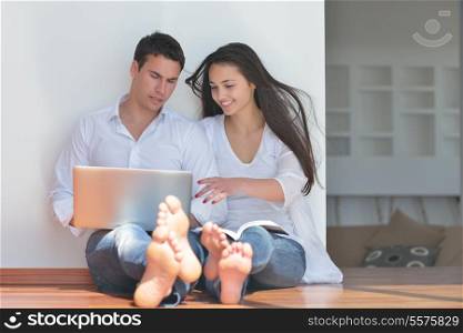 happy young relaxed couple working and playing on laptop computer at home