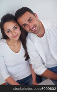 happy young relaxed couple working on laptop computer at modern home interior