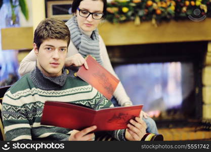 happy Young romantic couple and relaxing sofa in front of fireplace at winter season in home