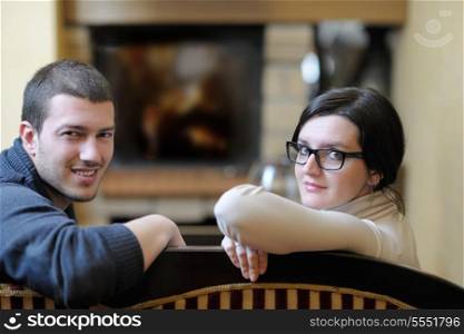 happy Young romantic couple and relaxing sofa in front of fireplace at winter season in home