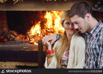 happy Young romantic couple and relaxing sofa in front of fireplace at winter season in home