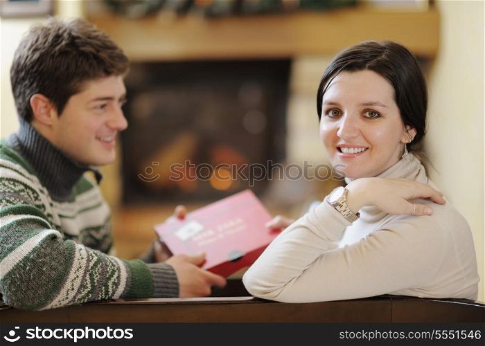 happy Young romantic couple relax on sofa in front of fireplace at winter season in home