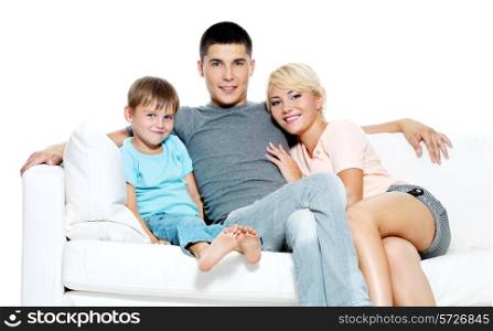 Happy young smiling family with kid sitting on white sofa - Isolated