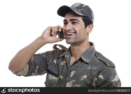 Happy young soldier having conversation on cell phone