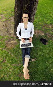 happy young student woman with laptop in city park study