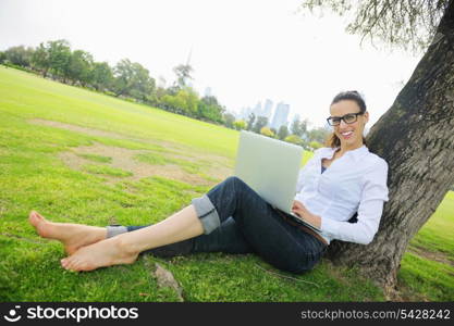 happy young student woman with laptop in city park study