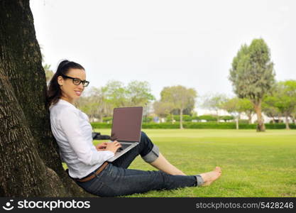 happy young student woman with laptop in city park study