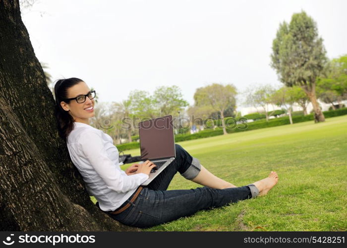 happy young student woman with laptop in city park study