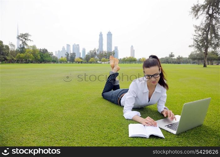 happy young student woman with laptop in city park study