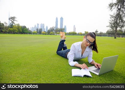 happy young student woman with laptop in city park study