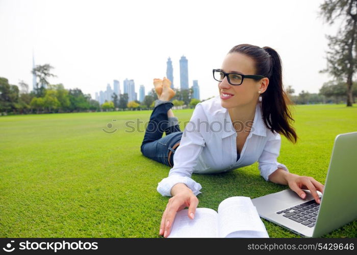 happy young student woman with laptop in city park study