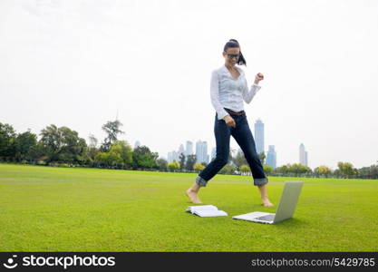 happy young student woman with laptop in city park study