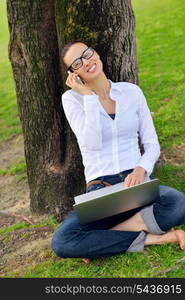 happy young student woman with laptop in city park study