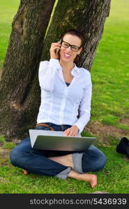 happy young student woman with laptop in city park study