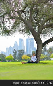 happy young student woman with laptop in city park study