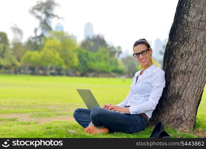 happy young student woman with laptop in city park study