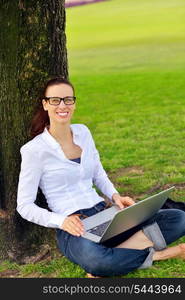 happy young student woman with laptop in city park study