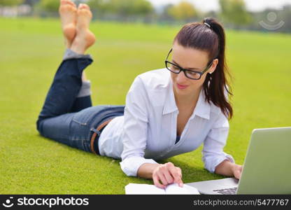 happy young student woman with laptop in city park study