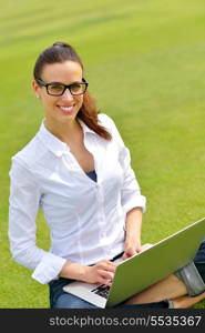 happy young student woman with laptop in city park study